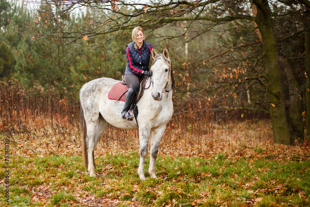 Fototapeta premium Young woman riding a horse