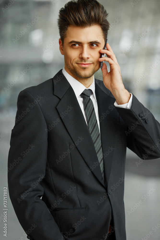 Businessman Talking on the Phone and Smiling Businessman Talking on the Phone and Smiling