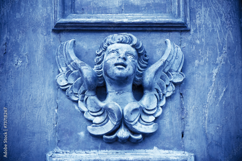 Sculpture of an angel on a wooden door in Italy - toned image