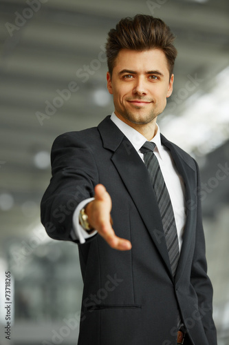 Portrait of a successful businessman giving a hand