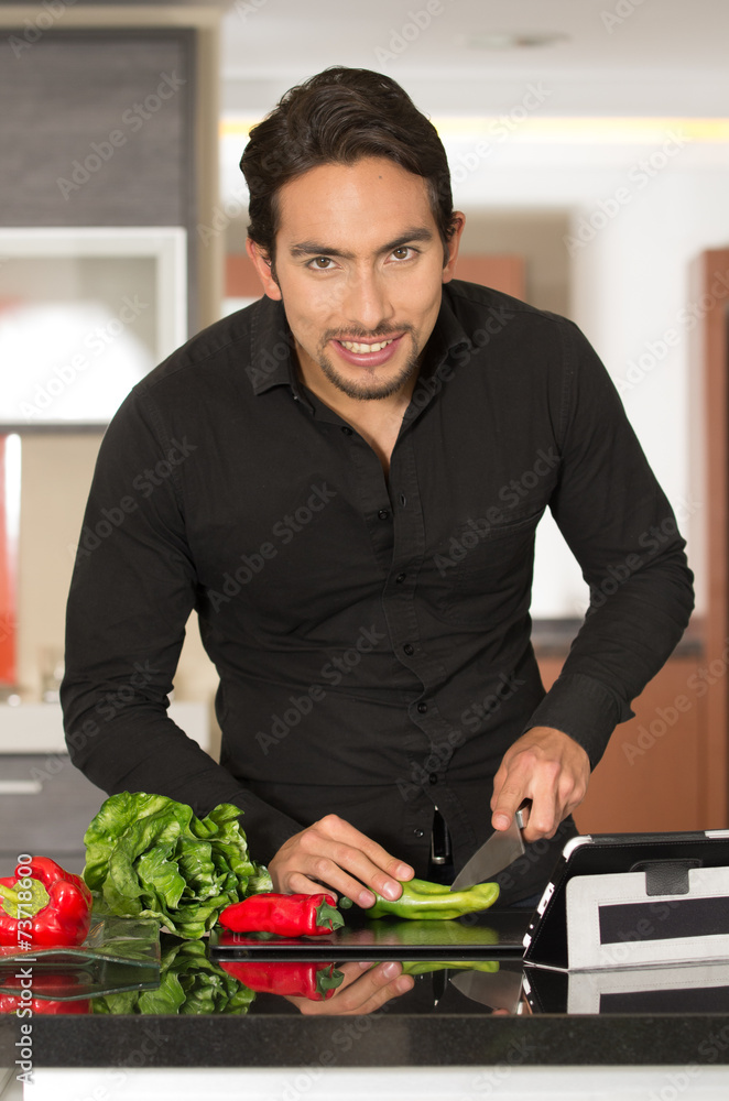 Plakat handsome young modern man cooking healthy recipe and using
