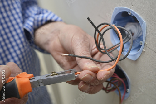 Electrician installing electrical outlet