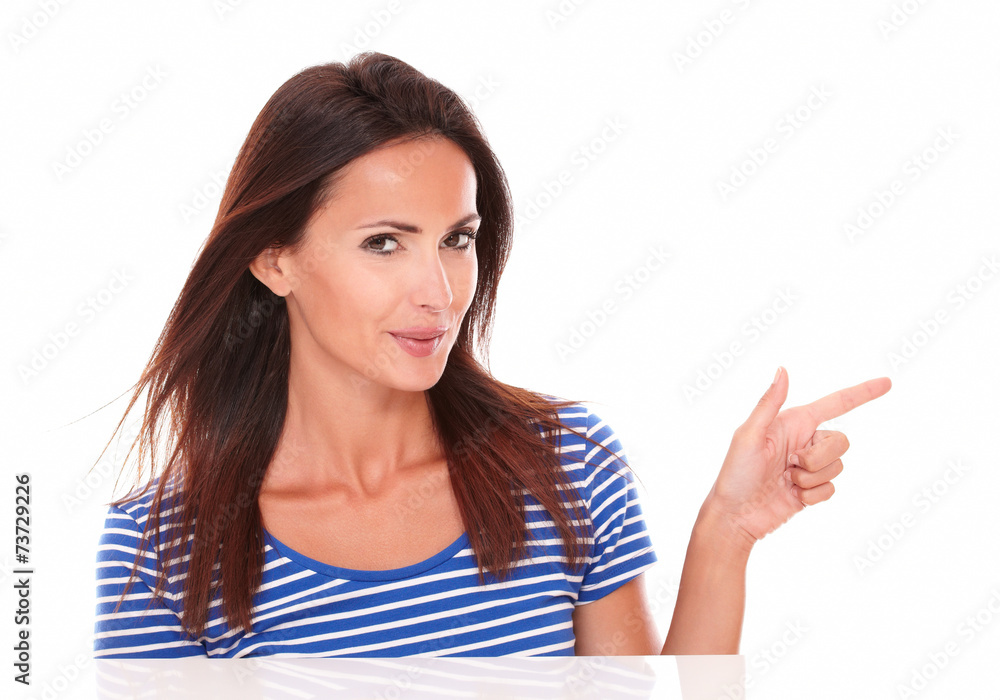 Young brunette pointing to her left