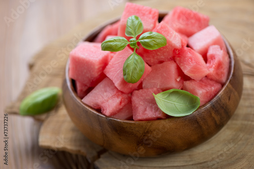 Close-up of watermelon cubes in a wooden bowl, studio shot