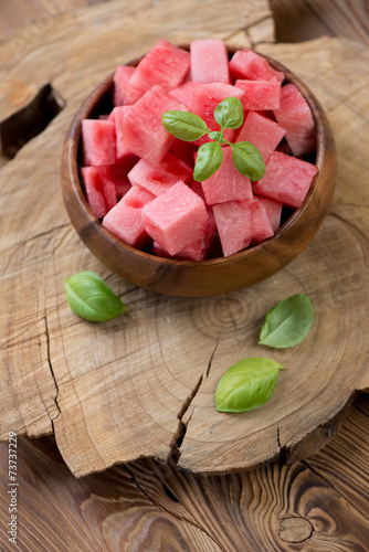 Wooden bowl with watermelon cubes, high angle view, studio shot