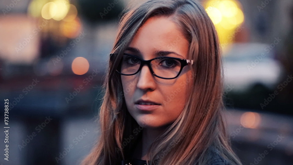 Pretty, serious woman looking into the camera in the city Pretty, serious woman looking into the camera in the city