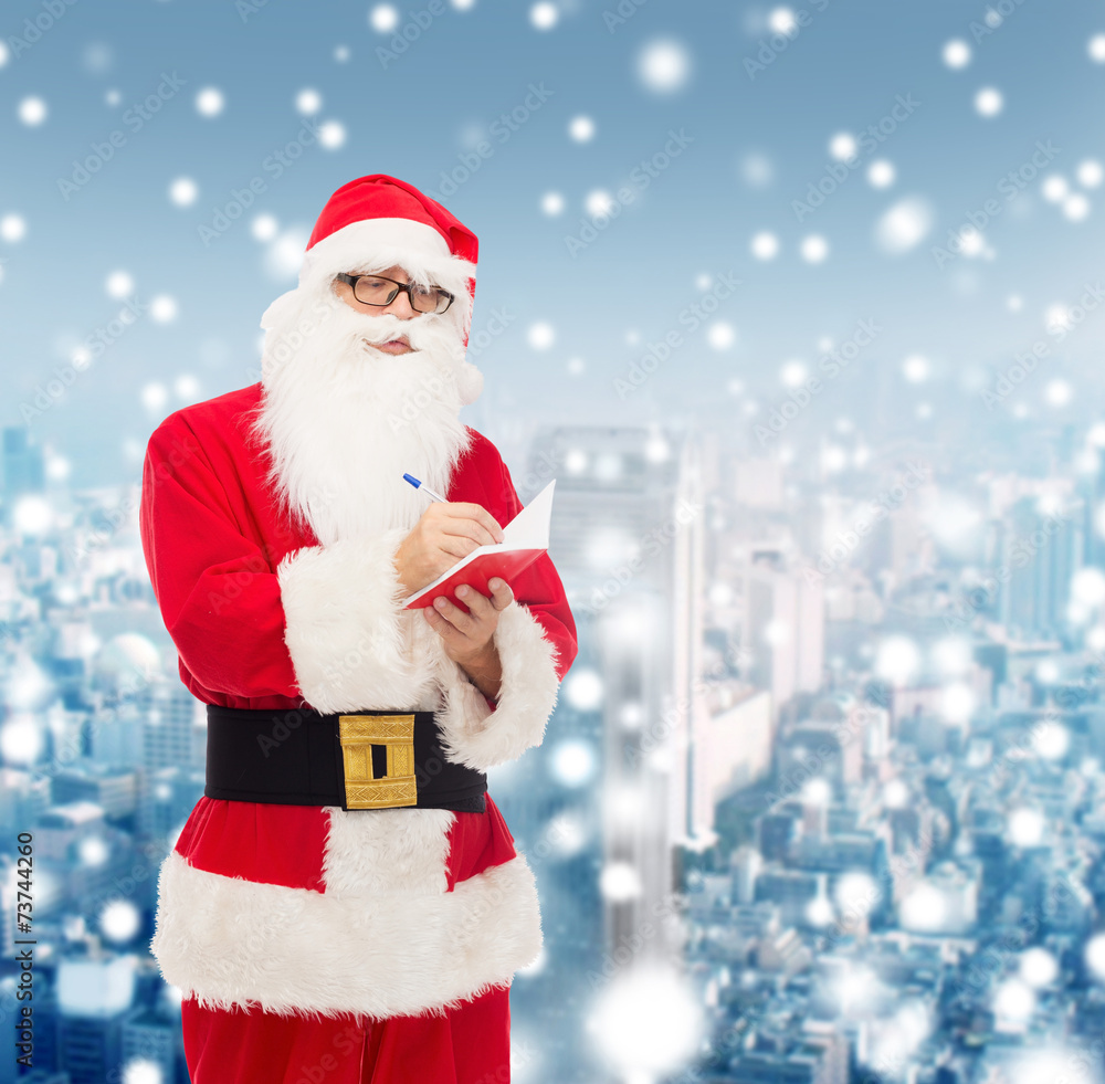 man in costume of santa claus with notepad man in costume of santa claus with notepad