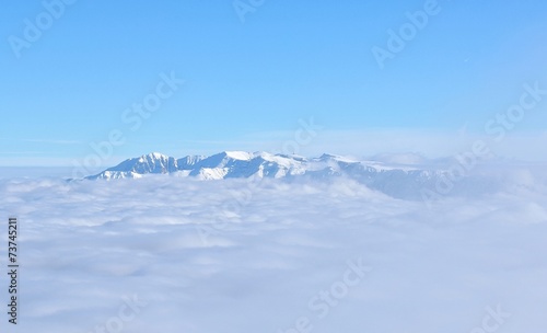 Top of high mountains, covered by snow and fog
