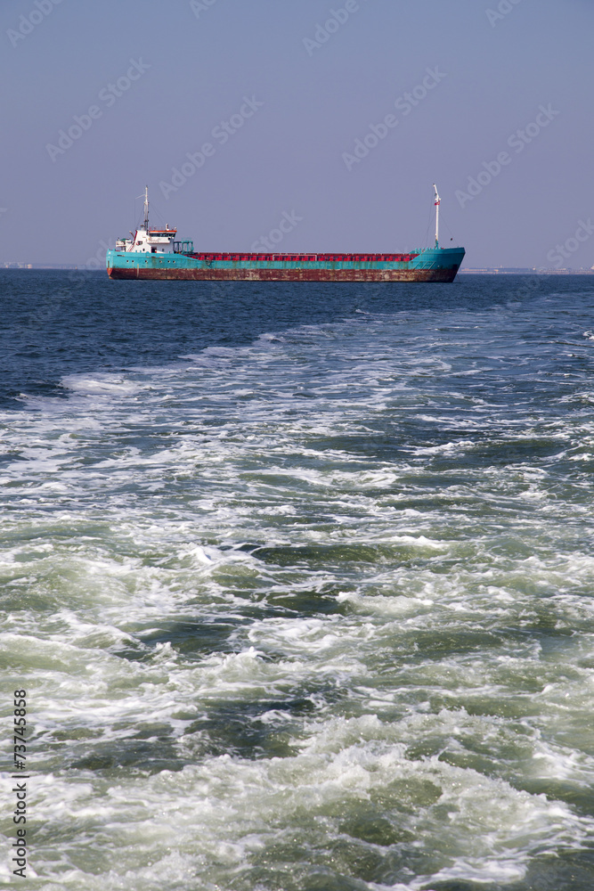 Cargo ship on the sea with waves foreground