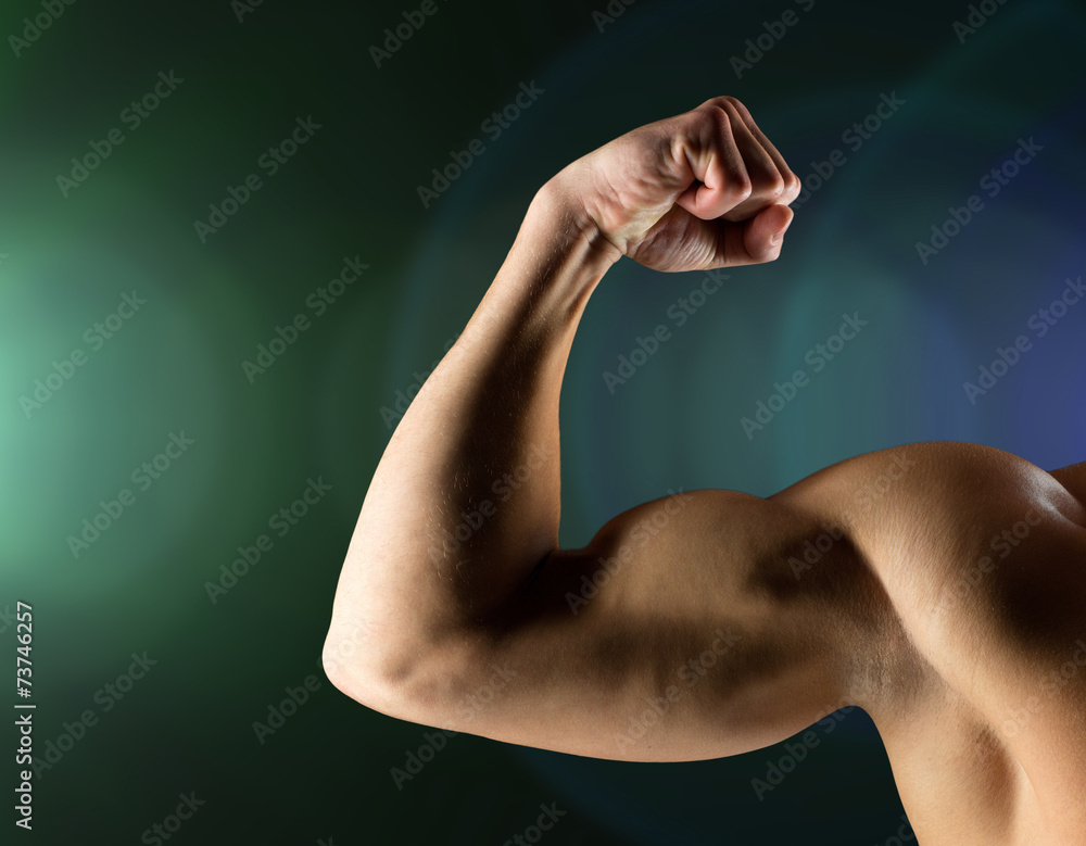Fototapeta premium close up of young man flexing and showing biceps