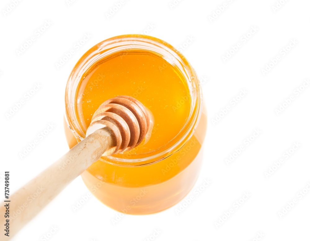 honey jar on white background with wooden honey dipper on top honey jar on white background with wooden honey dipper on top