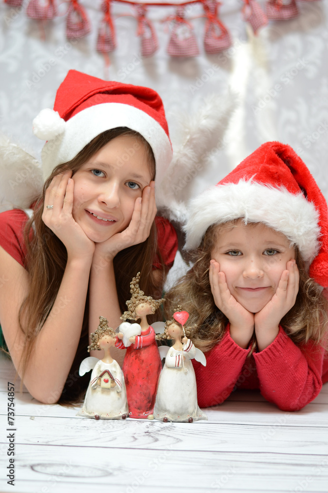 Two glad sisters with santa caps Two glad sisters with santa caps