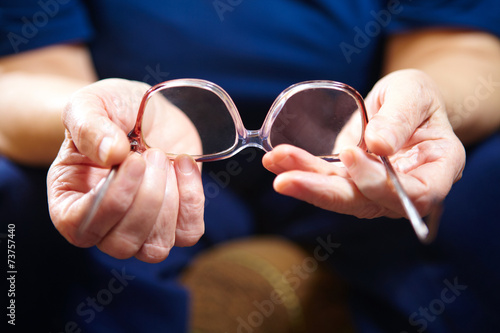 Old woman hands with eyeglasses