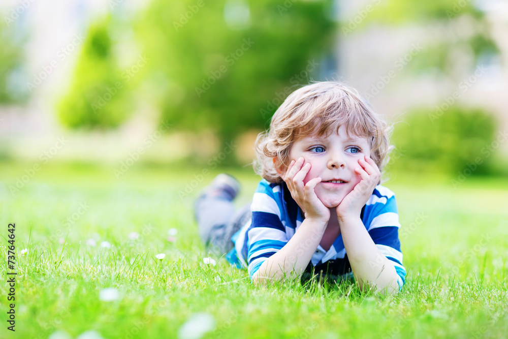 Happy child enjoying on grass field and dreaming Happy child enjoying on grass field and dreaming