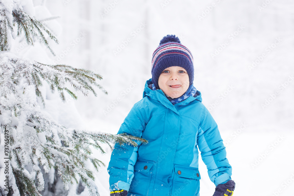 Little toddler boy having fun with snow outdoors on beautiful wi Little toddler boy having fun with snow outdoors on beautiful wi