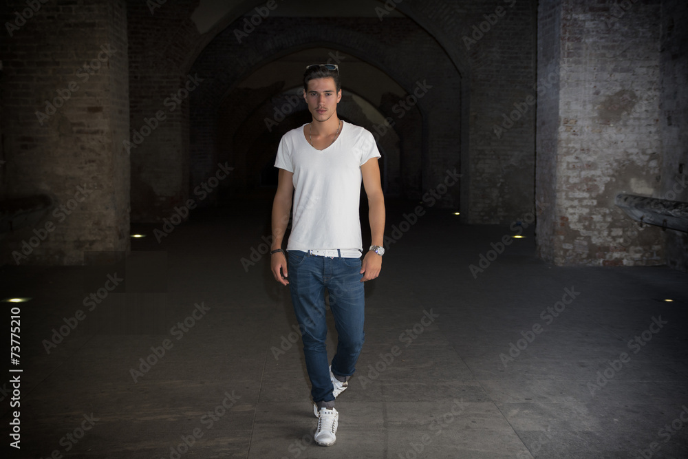 Handsome young man in old building walking inside gallery Handsome young man in old building walking inside gallery