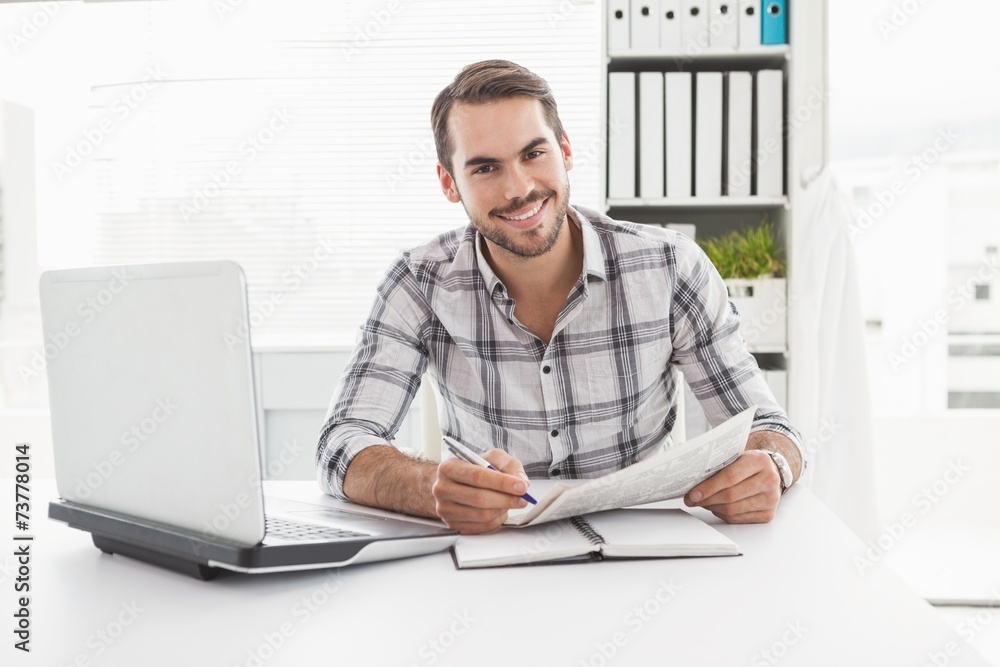 Casual businessman writing on newspaper Casual businessman writing on newspaper