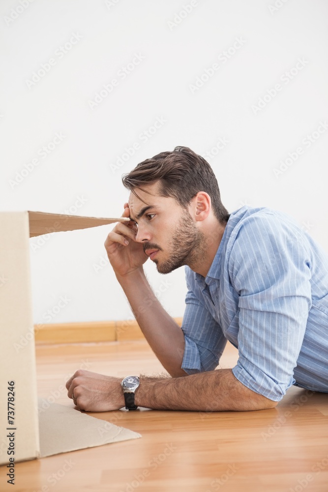 Casual man looking inside cardboard box Casual man looking inside cardboard box