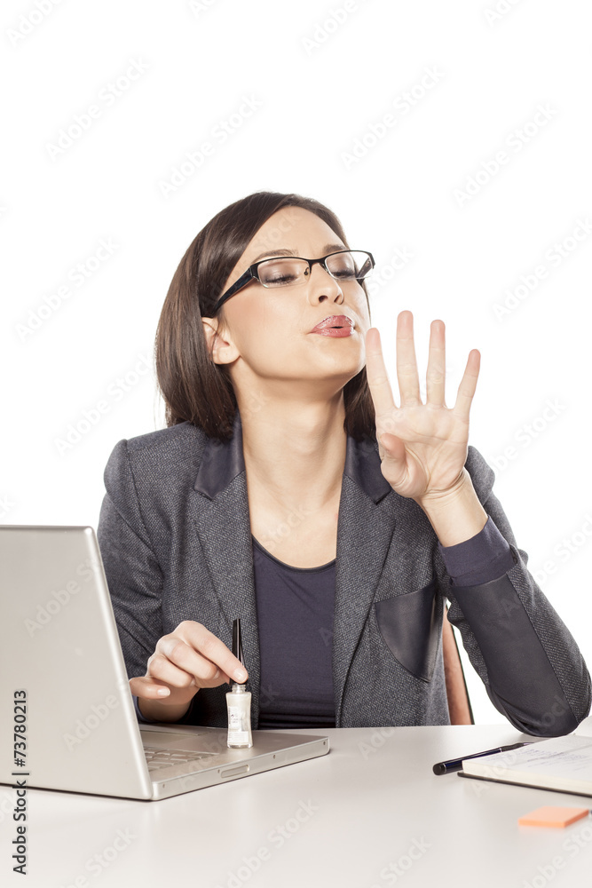 young businesswoman applied nail polish on her workplace young businesswoman applied nail polish on her workplace
