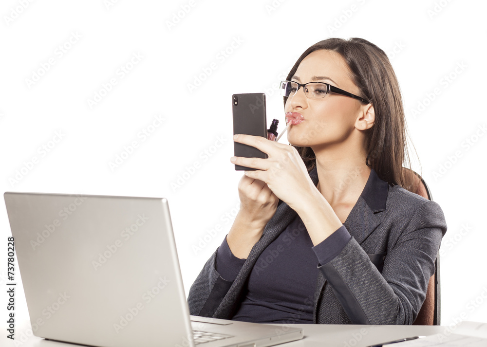 young businesswoman applied lip gloss on her workplace young businesswoman applied lip gloss on her workplace
