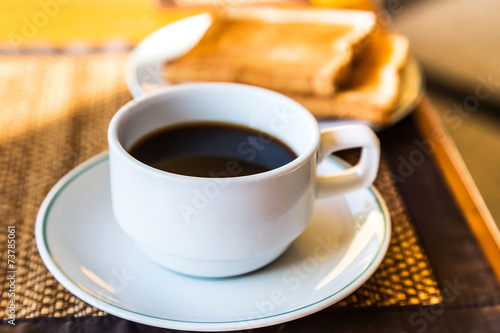 black coffee in white cup and toasts