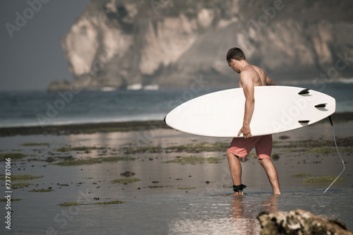 Photography Surfer with surfboard on the beach