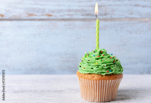 Photography Delicious birthday cupcake on table on wooden background