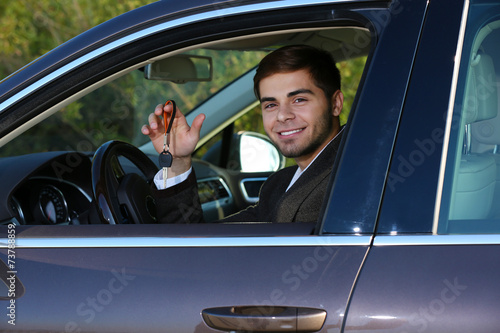 Man with car key in car