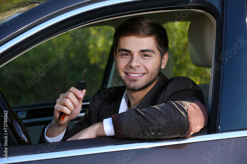 Man with car key in car