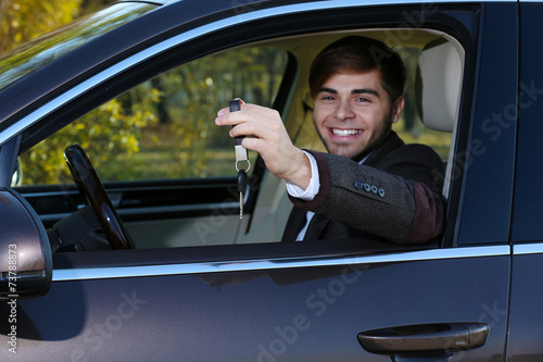 Man with car key in car