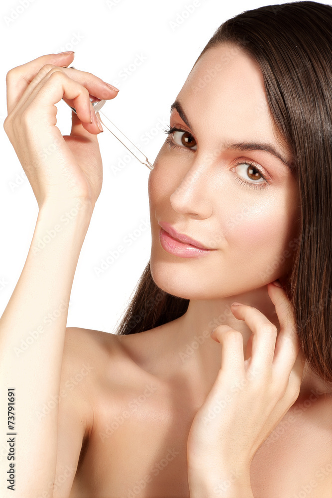 Beautiful model applying a cosmetic skin serum treatment