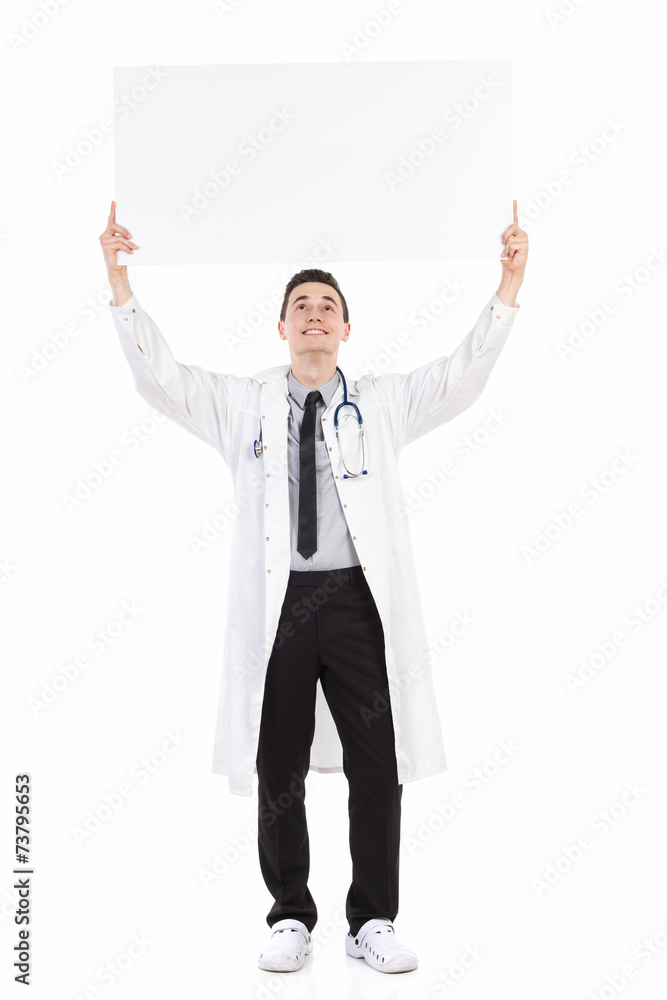 Happy male doctor holding empty placard over his head Happy male doctor holding empty placard over his head