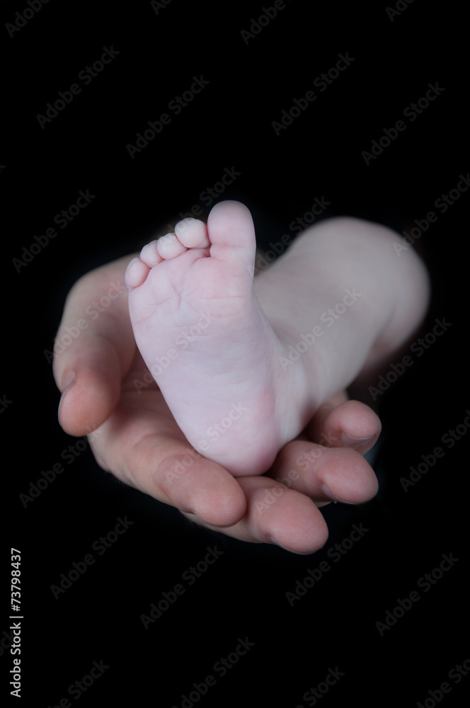 Baby legs. Legs newborn on a black background