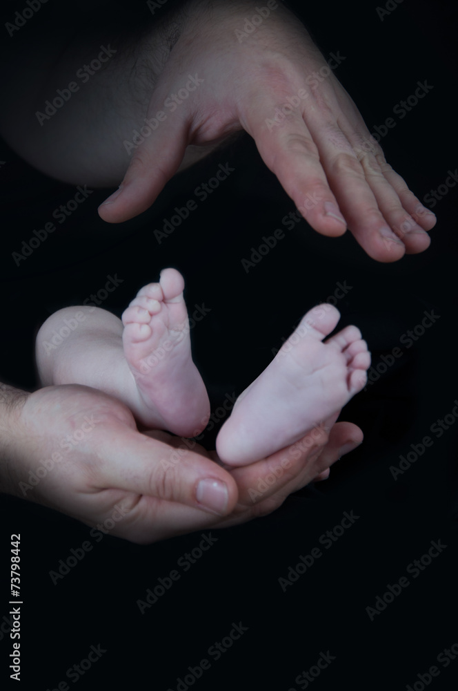 Baby legs. Legs newborn on a black background