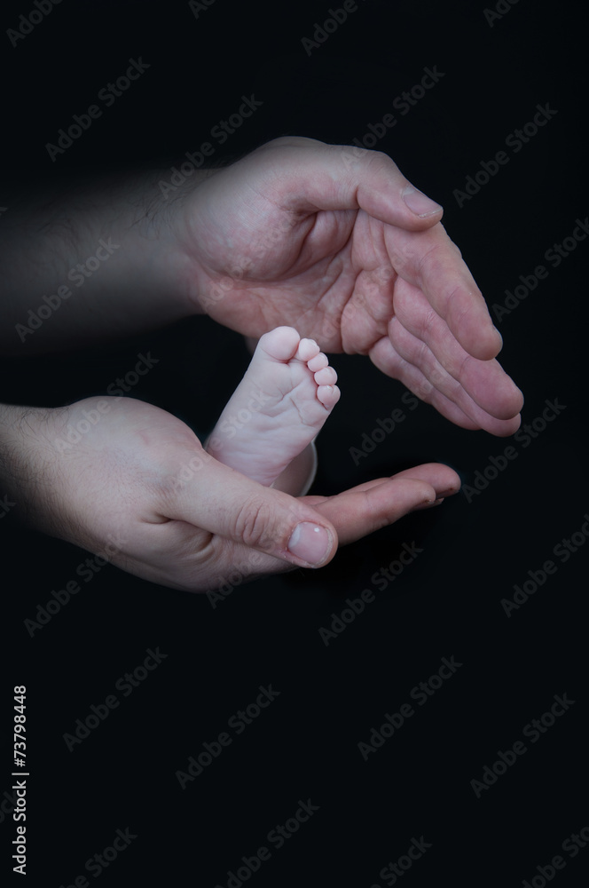 Baby legs. Legs newborn on a black background
