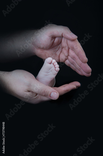 Obraz na płótnie Baby legs. Legs newborn on a black background w salonie
