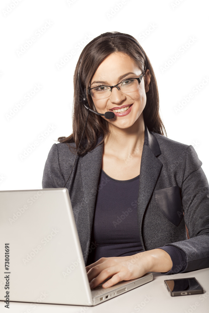 smiling girl working in the call center and posing on the desk smiling girl working in the call center and posing on the desk