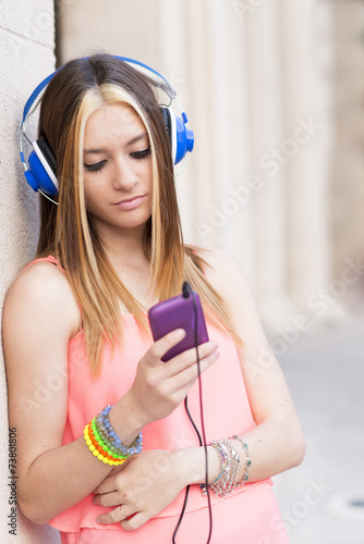 Beautiful woman with hearphones looking smart phone, modern life photo