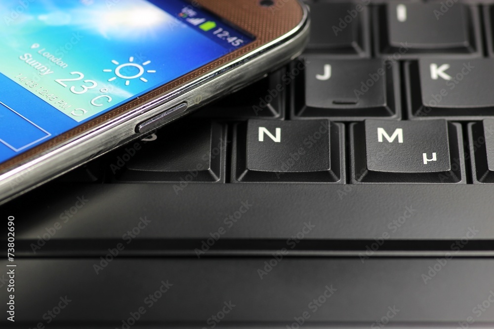 Handy auf Laptoptastatur Handy auf Laptoptastatur