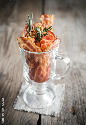 Fried bacon strips with fresh rosemary