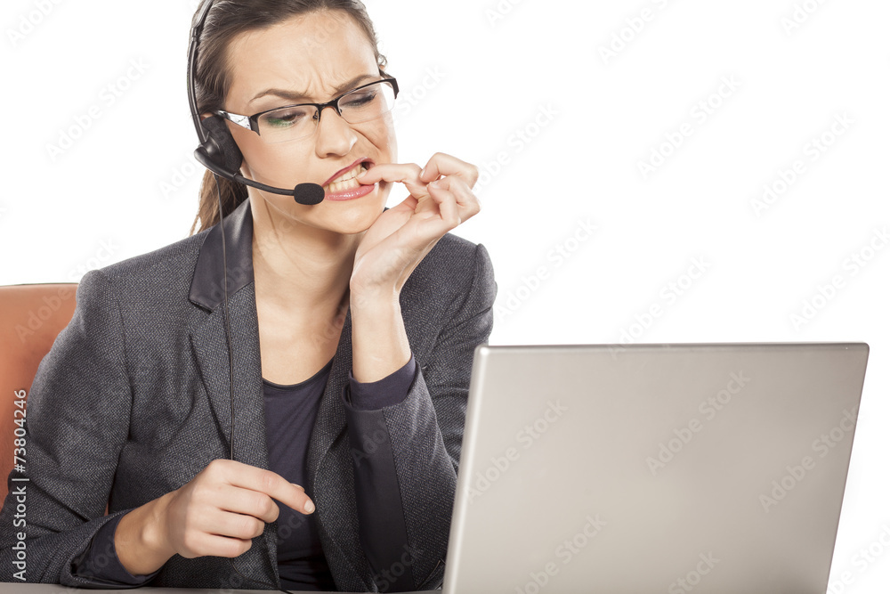The girl working in the call center biting his fingernails The girl working in the call center biting his fingernails