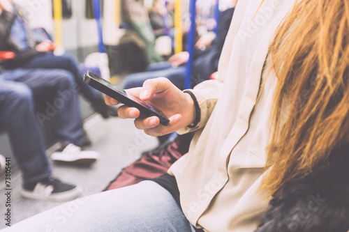 Young Woman Using Smart Phone in London Tube