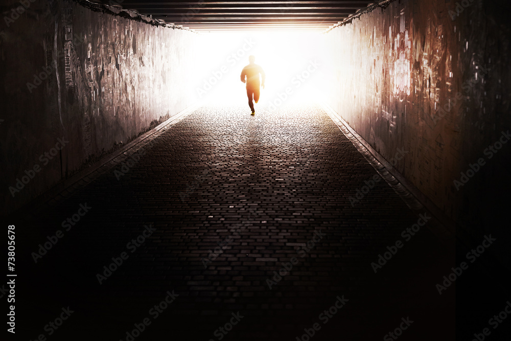Man running through the tunnel in the sun - obrazy, fototapety, plakaty 