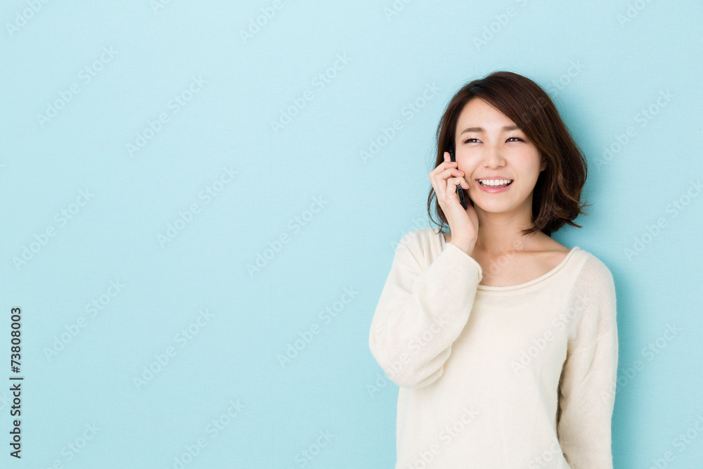 attractive asian woman talking on blue background attractive asian woman talking on blue background