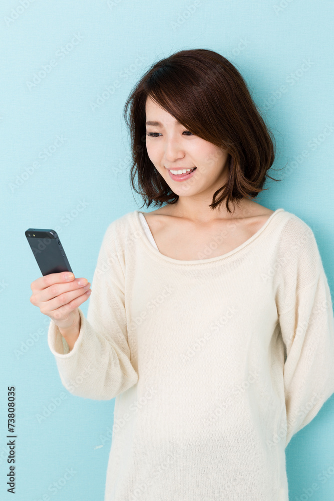 attractive asian woman using smart phone on blue background attractive asian woman using smart phone on blue background