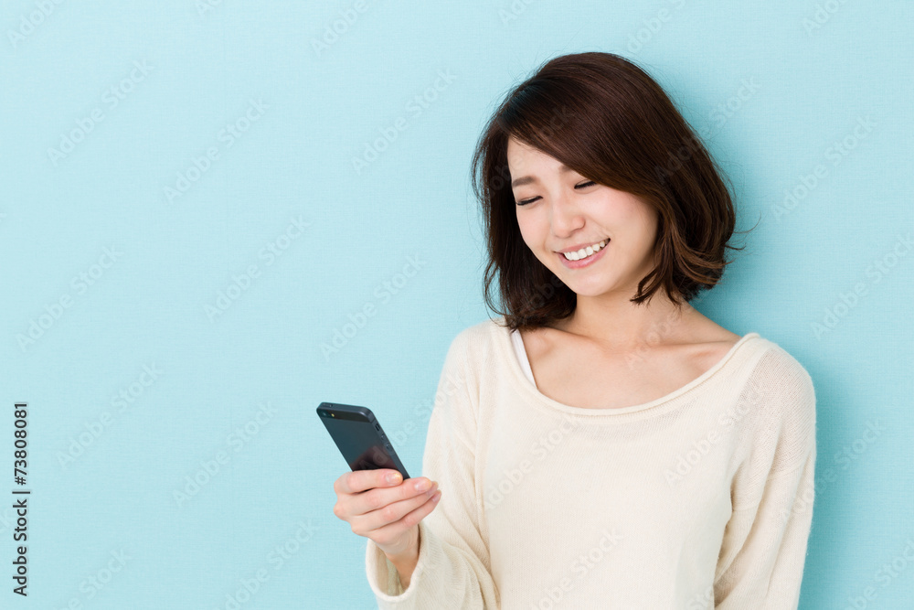 attractive asian woman using smart phone on blue background attractive asian woman using smart phone on blue background