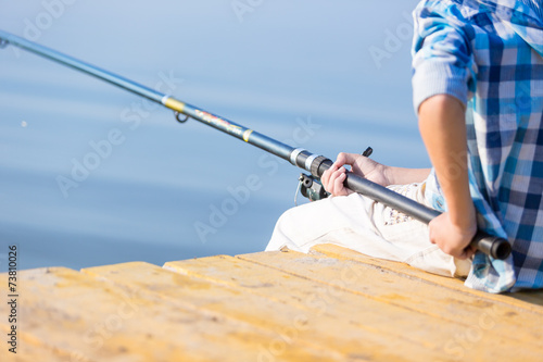 Close-up of hands of a boy with a fishing rod