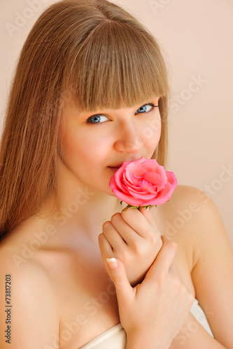 Beautiful Girl with Rose Flower Touching her Face. Skincare conc
