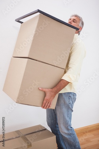 Man balancing heavy cardboard boxes © WavebreakmediaMicro