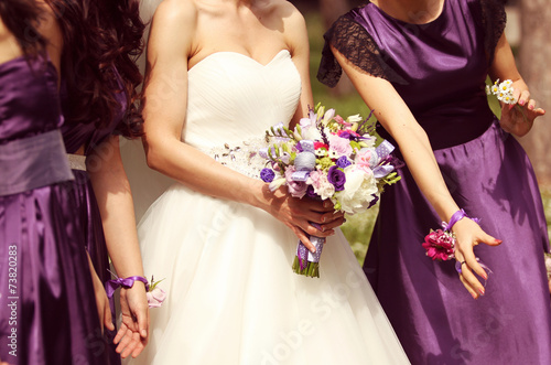 Detail and bride and bridesmaid with flowers photo